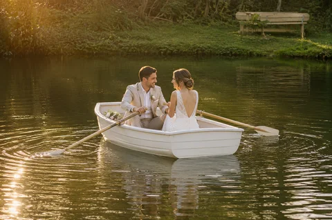 A wedding couple sitting in a rowing boat on the Longlands lake