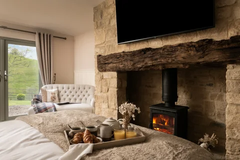 A bed beside an original stone fireplace in Lakeview Farmhouse