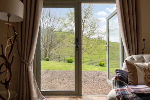 Bedroom window and curtains framing the view across the valley