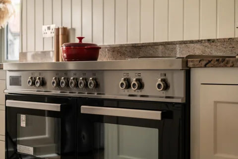 Range cooker beneath a tiled splashback in the Farmhouse kitchen