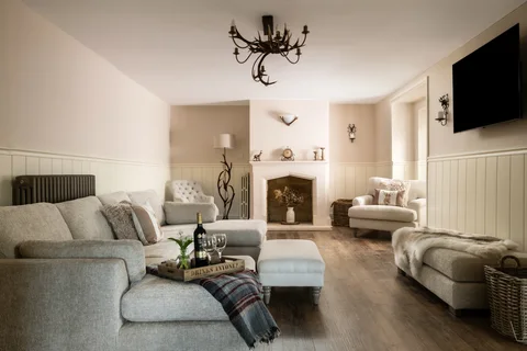 Sofas and a stone fireplace in the light-filled Farmhouse sitting room