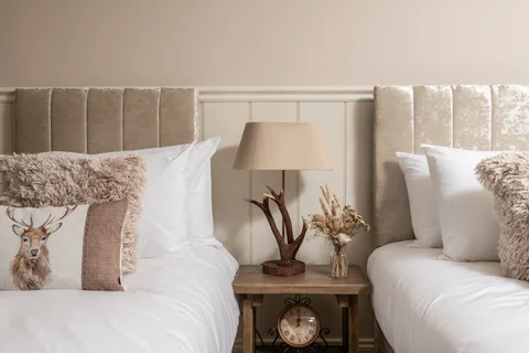 Twin bed pillows and a shared bedside table in the Farmhouse