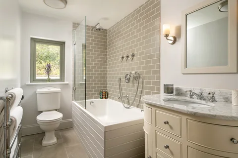 A bathroom basin, mirror and neutral wall panelling