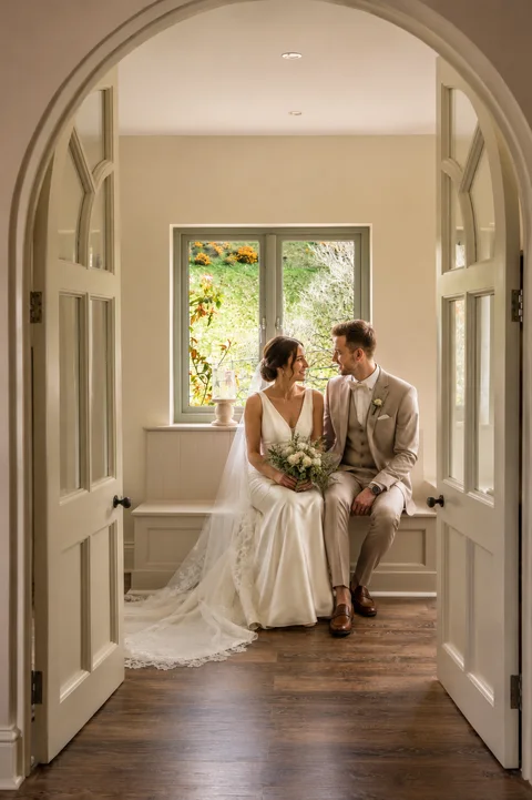 A wedding couple framed by the Farmhouse arched doorway