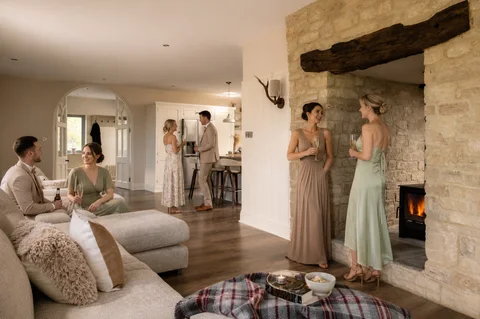 A wedding party gathered beside the Farmhouse stone fireplace