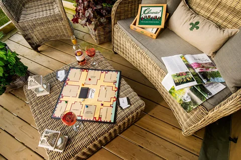 Board games on a table between wicker chairs on a lodge deck