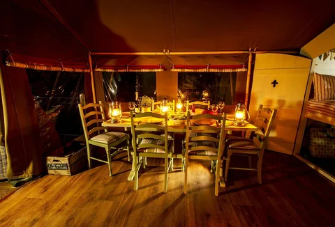 A Safari Lodge dining table lit by candles in the evening