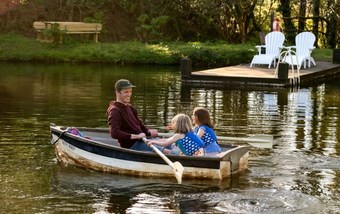 Family rowing boat on Longlands Devon private lake for wild swimming and nature adventures