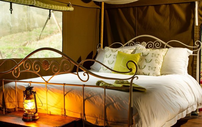 Luxury safari lodge bedroom at Longlands Devon with king size bed and cosy lantern lighting