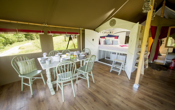 Safari lodge dining area with hidden bunk bed sleeping space at Longlands Devon North Devon