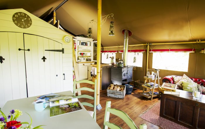 Safari lodge lounge with log burner and kitchenette at Longlands Devon luxury glamping North Devon